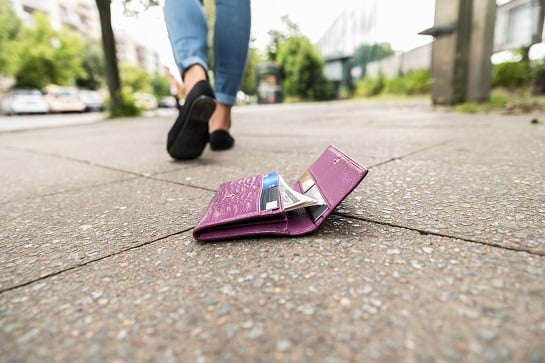 Lady walking away from her wallet on the ground  image